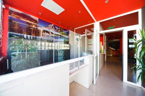 a restaurant with red ceilings and plants on the wall at Aparthotel Autosole in Estepona