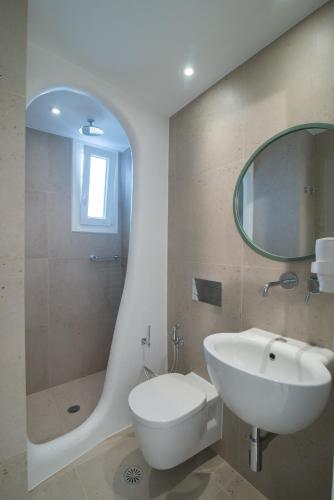 a bathroom with a sink and a toilet and a mirror at Spiros in Naxos Chora