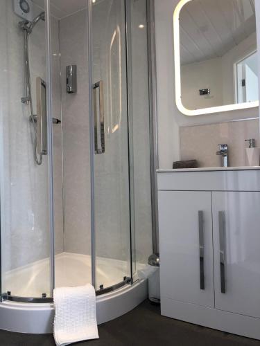 a bathroom with a shower and a sink at The Bungalows Guesthouse in Threlkeld