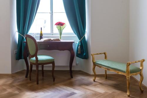 a table and chairs in a room with a window at Barbo Palace Apartments and Rooms in Ljubljana