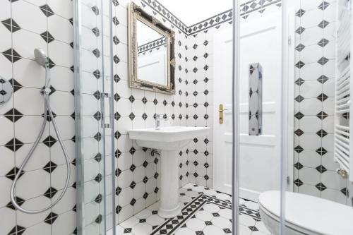 a bathroom with black and white tiled walls and a sink at Barbo Palace Apartments and Rooms in Ljubljana