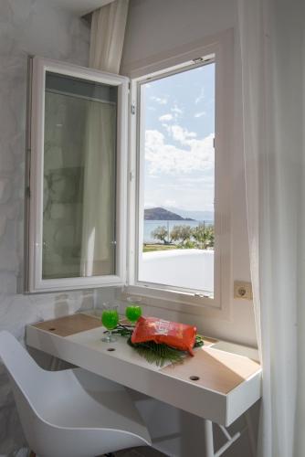 a bathroom with a window and a table and a chair at Spiros in Naxos Chora