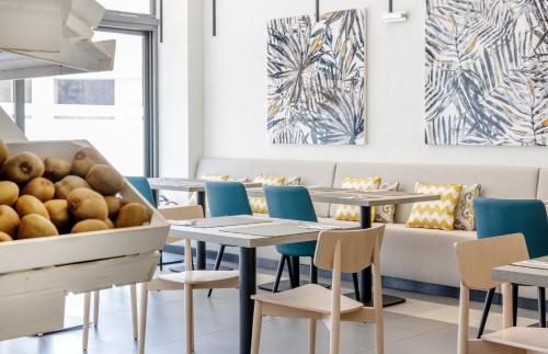 a restaurant with tables and chairs and a couch at Ilunion Sancti Petri in Chiclana de la Frontera