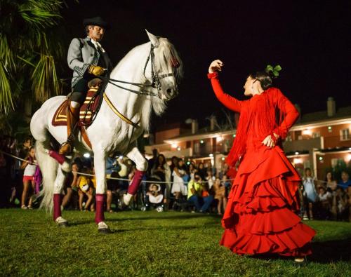 a man and a woman standing next to a white horse at Ilunion Sancti Petri in Chiclana de la Frontera