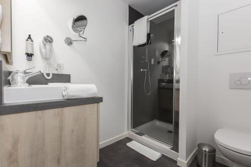 a bathroom with a shower and a sink and a toilet at Odalys City Le Mans Centre Congrès in Le Mans