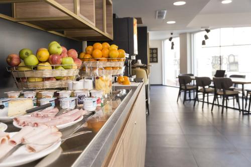 - un buffet dans un restaurant avec des fruits et des légumes dans l'établissement Appart'hôtel Odalys City - Le Mans Centre Palais des Congrès, au Mans