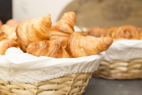 una cesta llena de croissants y otros pasteles en Appart'hôtel Odalys City - Le Mans Centre Palais des Congrès, en Le Mans