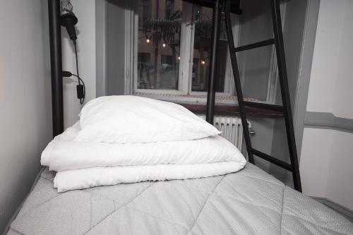 a stack of pillows on a bed with a ladder at City Backpackers Hostel in Stockholm