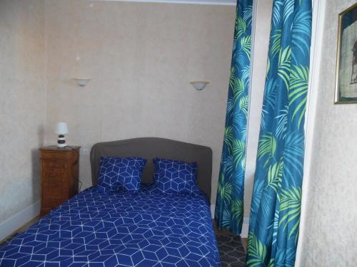 1 dormitorio con 1 cama azul con cortina azul y verde en COURS LA VILLE, en Cours la Ville