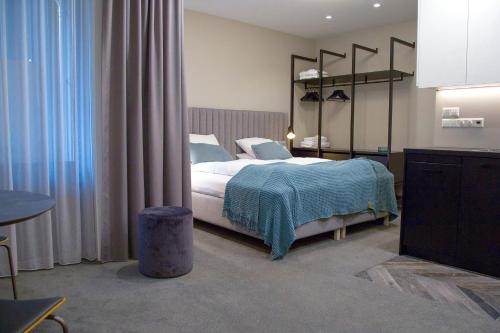 a bedroom with a bed with a blue blanket at Reykjavik Residence Apartment Hotel in Reykjavík