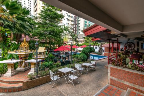 an outdoor patio with tables and chairs and a pool at Stable Lodge - SHA Certified in Bangkok