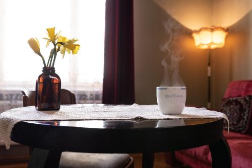stół ze świecą i wazonem w obiekcie Hostel, Pokoje gościnne Mleczarnia - Ozonowane we Wrocławiu