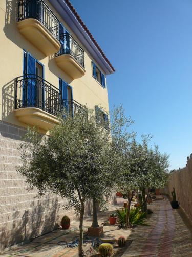 a building with blue balconies and trees in front of it at Hotel Mayarí Boutique Hotel in Calabardina