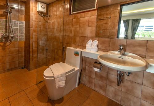 a bathroom with a toilet and a sink at Stable Lodge - SHA Certified in Bangkok