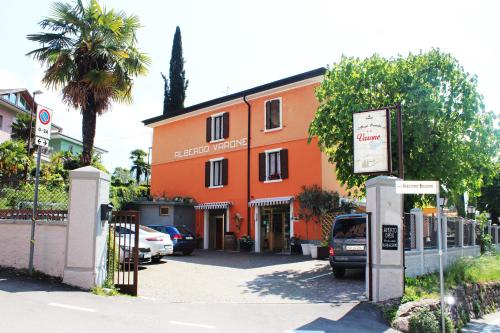 un edificio anaranjado con coches aparcados delante de él en Albergo Varone en Riva del Garda
