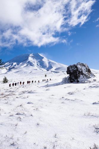a group of people walking up a snow covered mountain at Valle Corralco Hotel & Spa in Malalcahuello