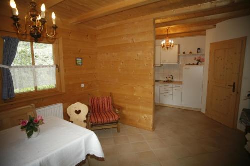 una habitación con mesa y una cocina en una cabaña en Ferienhaus Aussergraben, en Ultimo