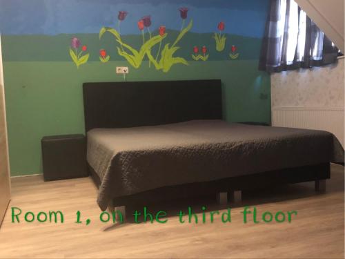 a bedroom with a bed with a flower mural on the wall at B&B nancy in holland met eigen badkamer , independent bathroom in Aalten