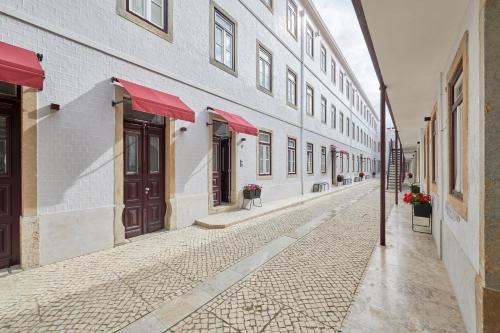 an empty street in an old building with red awnings at Vila Rosário in Graça in Lisbon