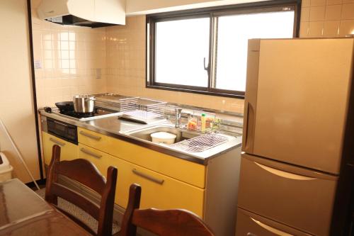 a small kitchen with a sink and a refrigerator at Guest House Dohei in Kamakura