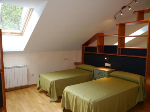 two beds in a room with a window at Villa Russell Hotel&Apartments in Torla