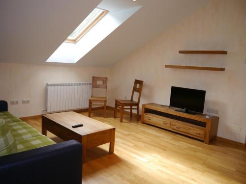 a living room with a couch and a flat screen tv at Villa Russell Hotel&Apartments in Torla
