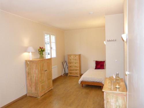 Un dormitorio con una cama y una cómoda y una ventana. en La Vergne, en Saint-Martin-des-Combes