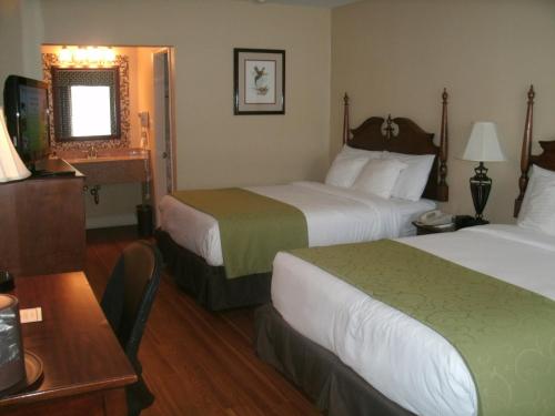 a hotel room with two beds and a table at Merry Acres Inn in Albany
