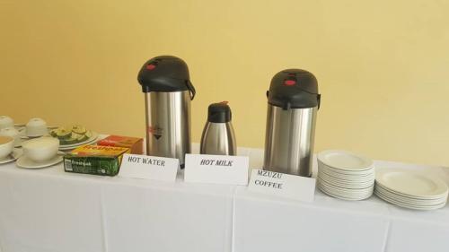 a counter with two thermos and plates on it at Wadonda Suites in Zomba