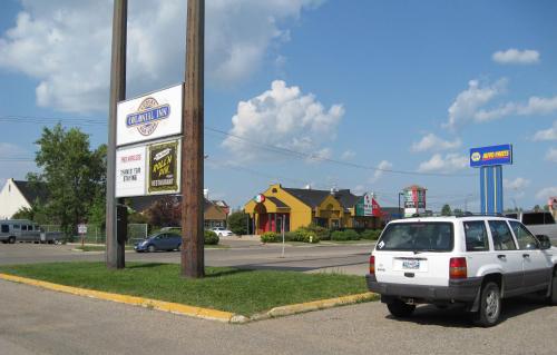 a white car parked next to a mobil gas station at Colonial Inn in Brandon