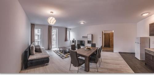 a living room with a dining table and a kitchen at Nova City Apartments in Budapest