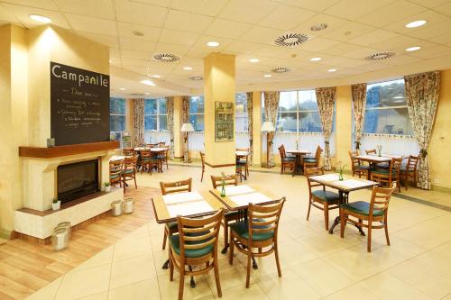 a restaurant with tables and chairs and a fireplace at Campanile Poznan in Poznań