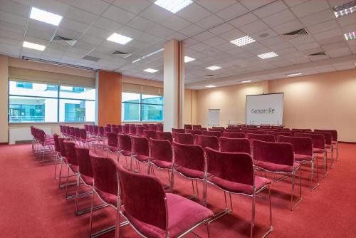 a conference room with red chairs and a whiteboard at Campanile Hotel Szczecin in Szczecin