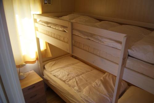 een slaapkamer met een stapelbed en een nachtkastje bij Lake View in Elburg
