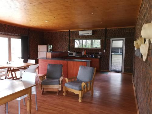 a living room with two chairs and a kitchen at En Route Guest House in Trompsburg