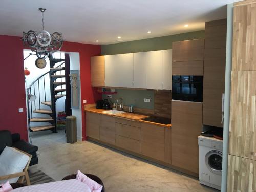 une cuisine avec des placards en bois et un escalier dans l'établissement La petite pause, à Montreuil