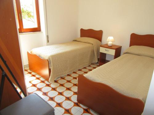 una camera con 2 letti e un pavimento piastrellato di Nicoletta's House - zona le dune - Porto Cesareo a Porto Cesareo