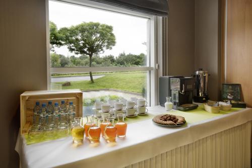 a counter with glasses and bottles on it with a window at Campanile Poznan in Poznań