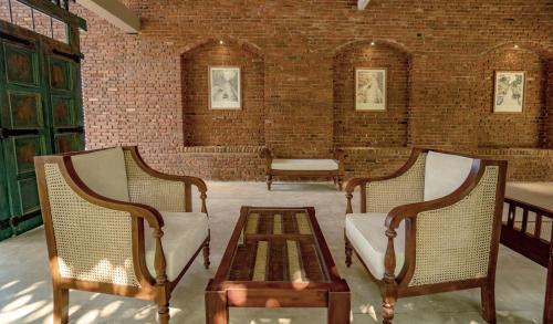 two chairs and a coffee table in a room at Ayur Ayur Resort & Ayurveda Retreat in Negombo