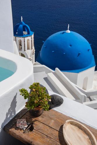 a potted plant sitting on a table on the side of a building at Sophia Oia View in Oia