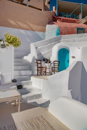a staircase with chairs and a blue door at Sophia Oia View in Oia