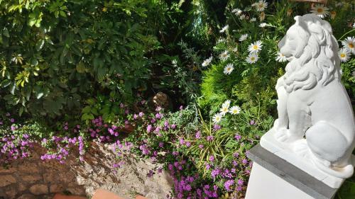 a white statue in a garden with flowers at Appartamento La Follicara in Anacapri