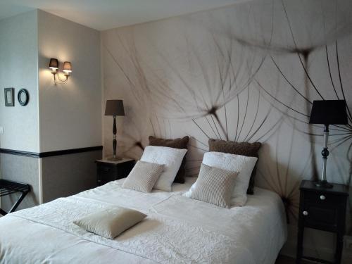 - une chambre dotée d'un grand lit avec des draps et des oreillers blancs dans l'établissement Chambre d'hôte le 18-20, à Saint-Martin-des-Entrées