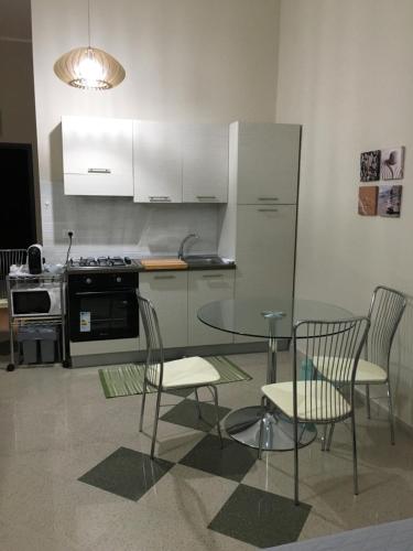 uma cozinha com uma mesa, cadeiras e um fogão em B&B Aliga em Porto Empedocle
