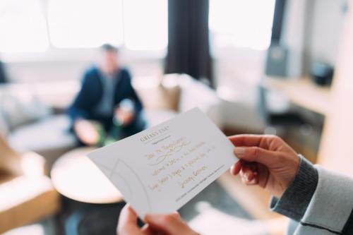 a person holding a piece of paper with writing on it at Hotel Enzian Hochsölden Superior in Sölden