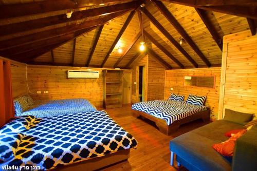 a bedroom with two beds and a couch in a room at Villa Joe in Peqi‘in H̱adasha