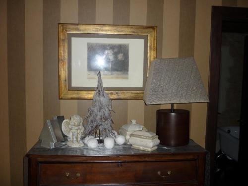 a table with a lamp and a picture on a wall at Casa Rural La Retuerta in Nava