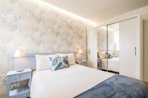 sypialnia z dużym białym łóżkiem i ścianą w obiekcie Ocean View by Encantos do Algarve - 910 w mieście Portimão