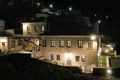 a large stone house at night with lights at "Apeiros Chora" Hotel, Zagori in Kato Pedina