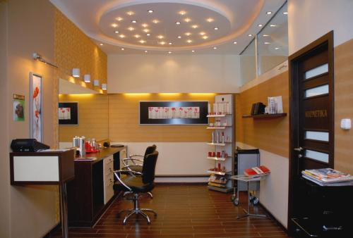 a hair salon with a desk and a chair at Sport Hotel in Debrecen